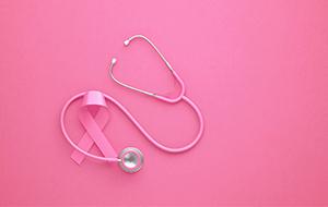 stethoscope with pink ribbon on pink background